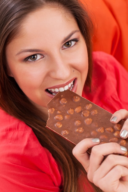 Hermosa mujer comiendo un chocolate