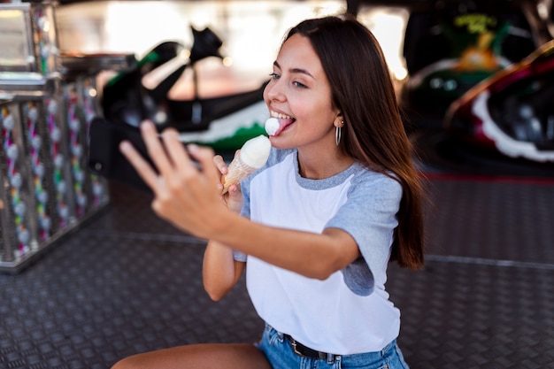 Foto gratuita hermosa mujer comiendo helado tomando selfie