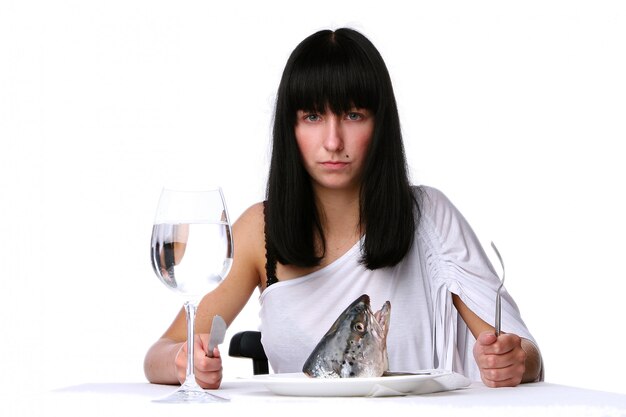 Hermosa mujer comiendo pescado fresco