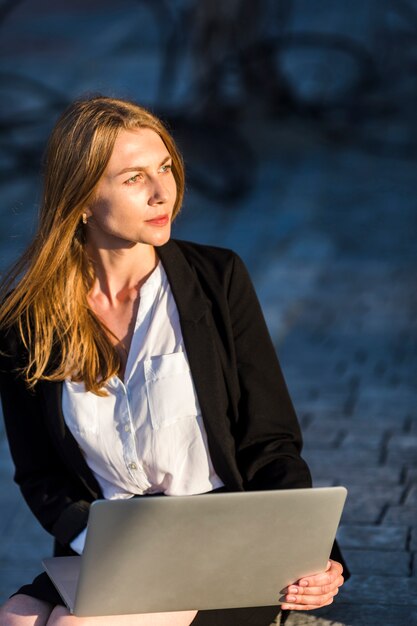 Hermosa mujer con una computadora portátil al aire libre