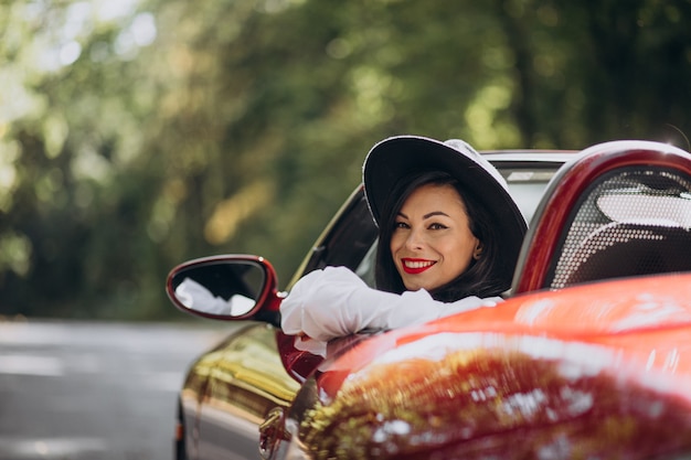 Hermosa mujer conduciendo cabrio rojo