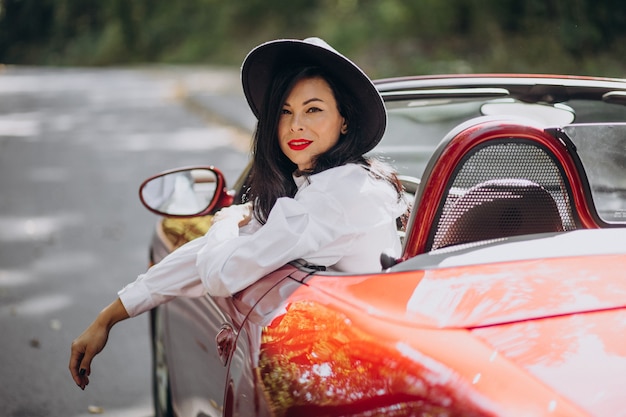 Foto gratuita hermosa mujer conduciendo cabrio rojo