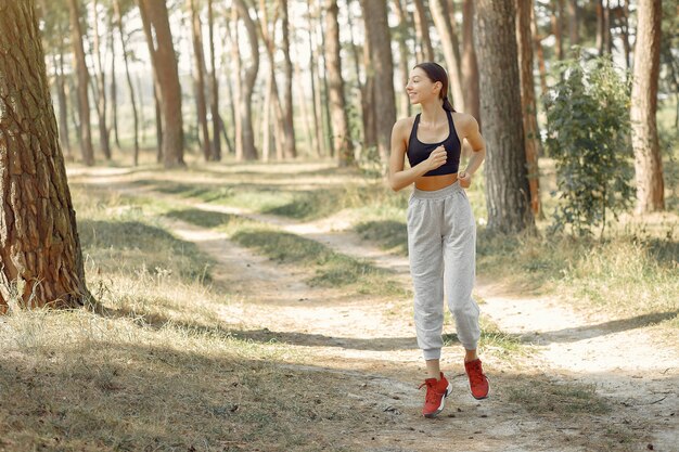 Hermosa mujer corre en un parque de verano