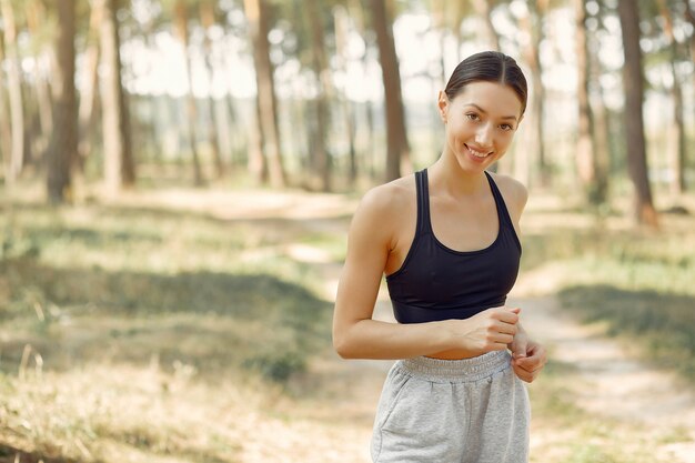 Hermosa mujer corre en un parque de verano