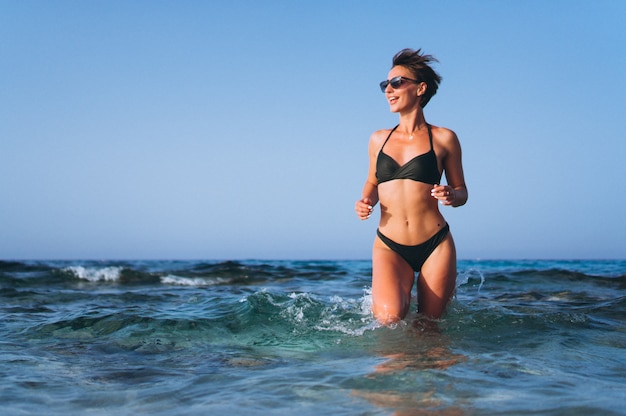 Foto gratuita hermosa mujer corriendo fuera del océano