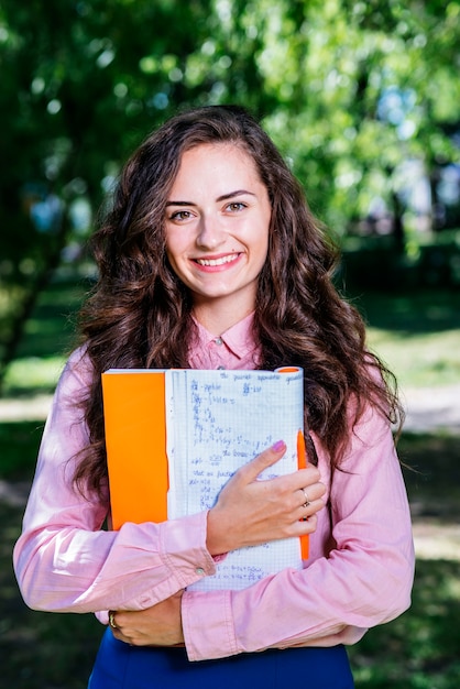 Foto gratuita hermosa mujer con el cuaderno en el parque