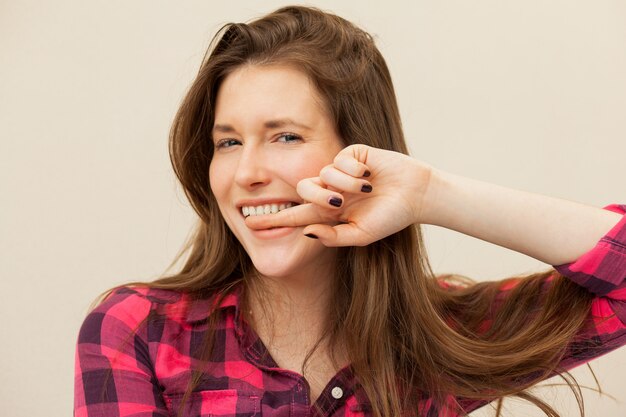 Hermosa mujer con el dedo en los dientes