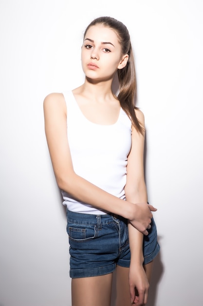 Hermosa mujer delgada en una camiseta, en blanco