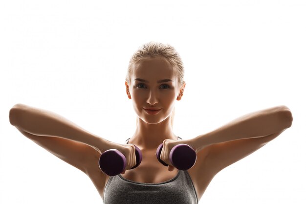 Hermosa mujer deportiva entrenamiento con pesas