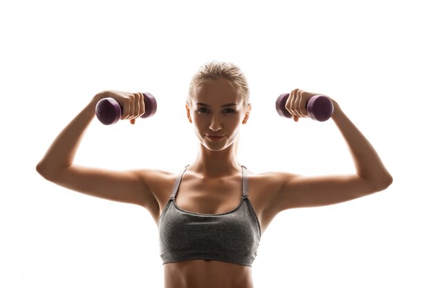 Hermosa mujer deportiva entrenamiento con pesas