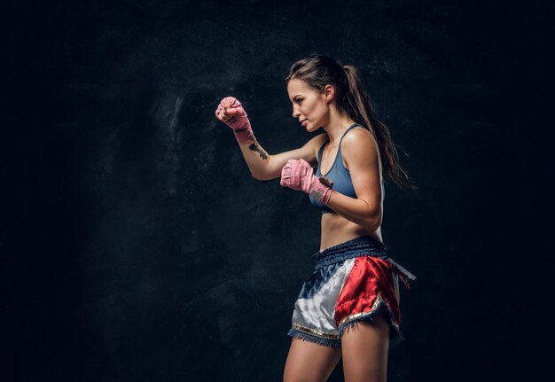 Hermosa mujer deportiva se está calentando antes de entrenar mientras posa para el fotógrafo.