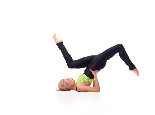 hermosa mujer deportiva haciendo un soporte de hombro posando con gracia