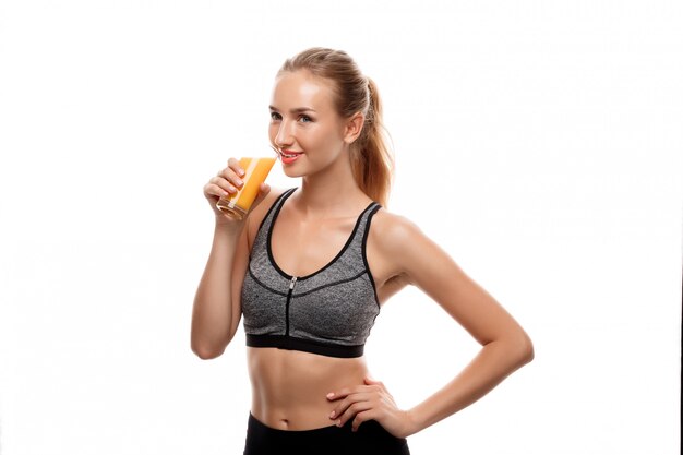 Hermosa mujer deportiva sosteniendo el vaso con jugo