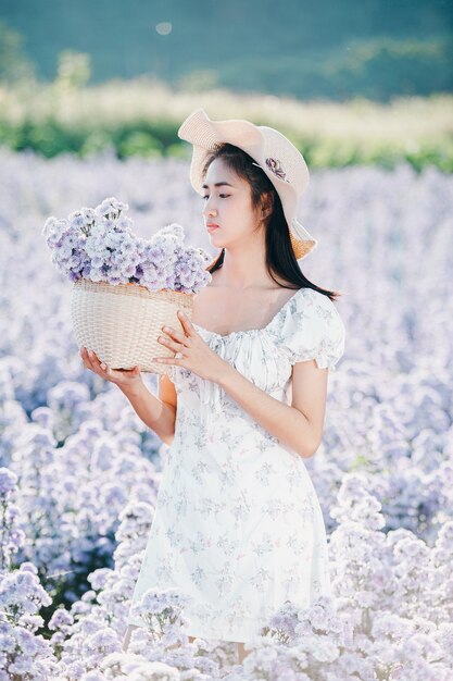 Hermosa mujer disfrutando de campo de flores