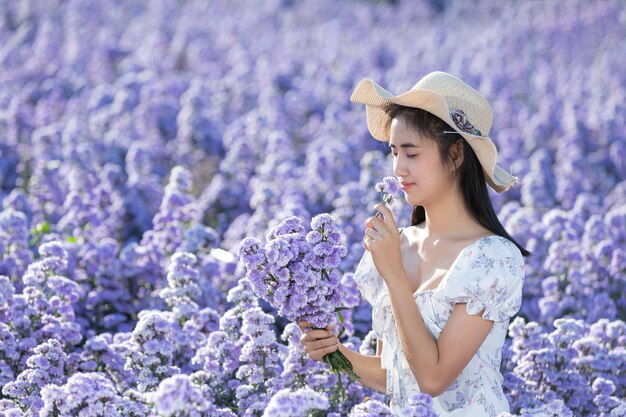 Hermosa mujer disfrutando de campo de flores