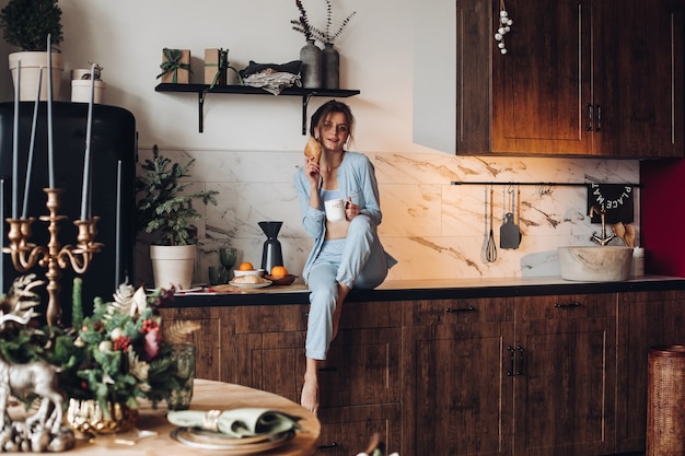 Hermosa mujer divirtiéndose en el desayuno. mañana de Navidad