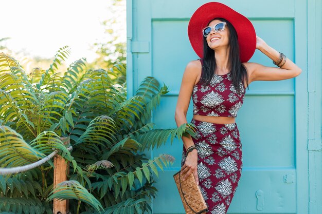 Hermosa mujer elegante con sombrero rojo posando en azul