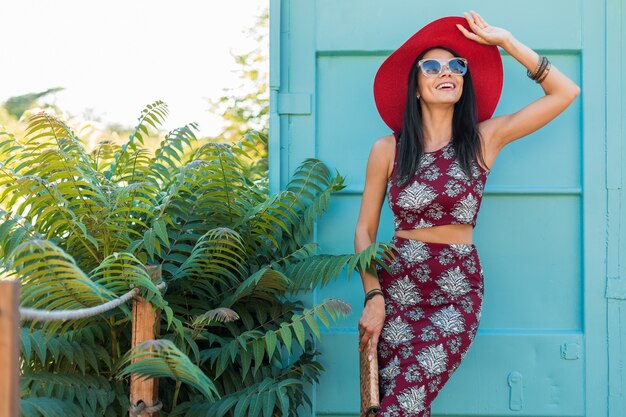 Hermosa mujer elegante con sombrero rojo posando en azul