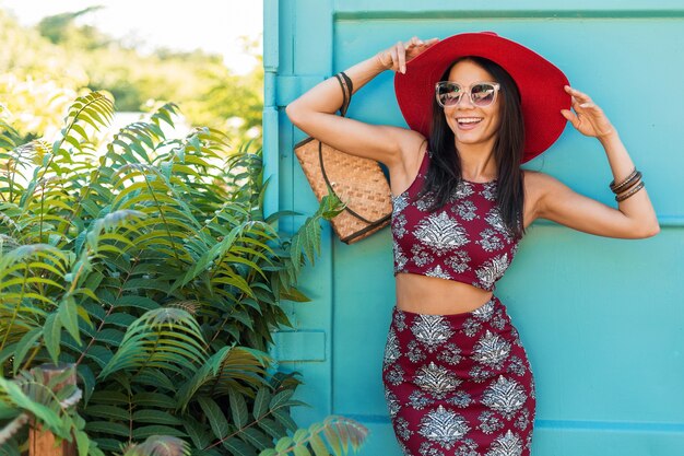 Hermosa mujer elegante con sombrero rojo posando en azul