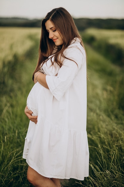 Hermosa mujer embarazada en un campo