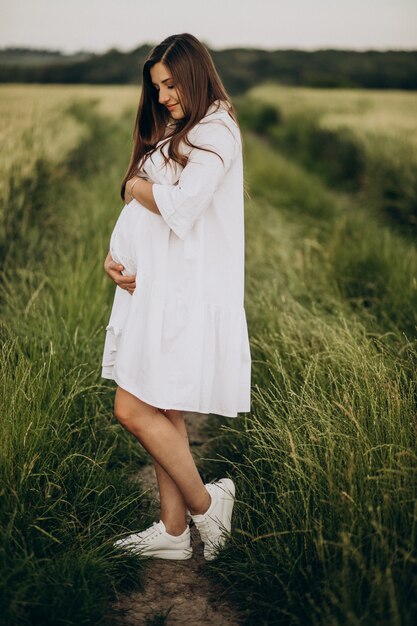 Hermosa mujer embarazada en un campo