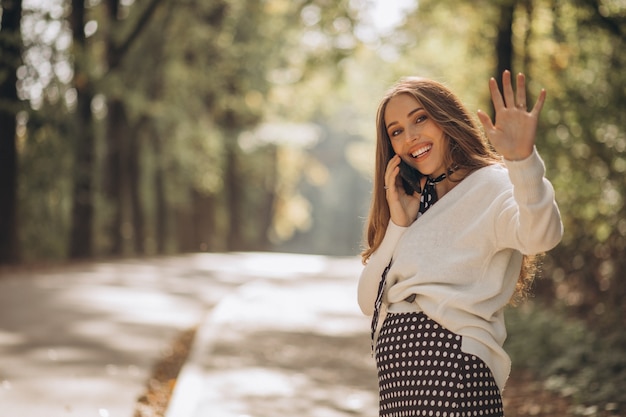 Hermosa mujer embarazada en un parque de otoño