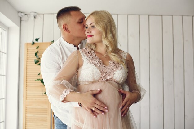 Hermosa mujer embarazada con su esposo en un estudio