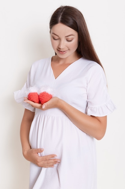 Foto gratuita hermosa mujer embarazada con vestido blanco