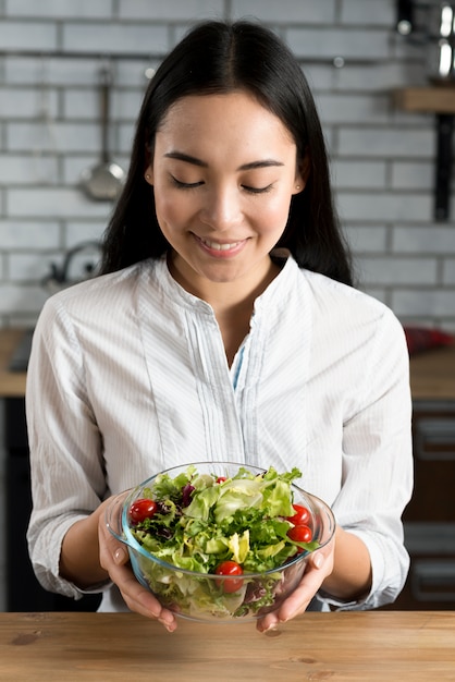 Hermosa mujer con ensalada en un tazón