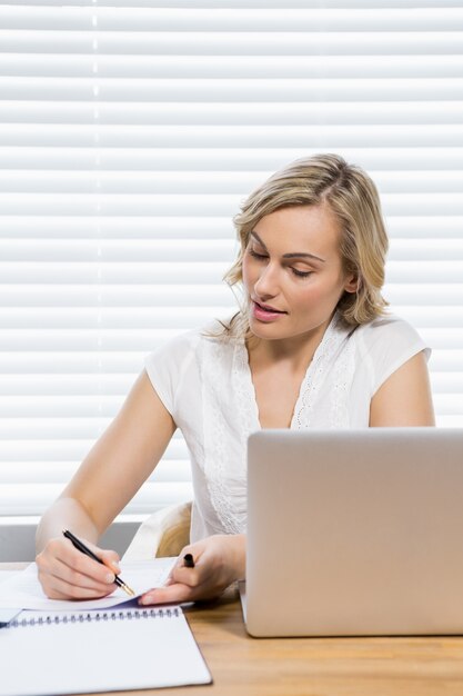 Hermosa mujer escribiendo en un papel