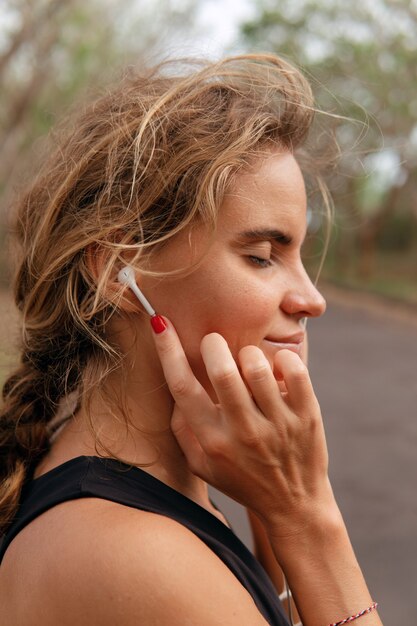 Hermosa mujer escuchando música en el parque