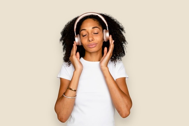 Hermosa mujer escuchando música a través de dispositivos digitales de auriculares