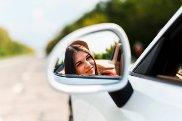 Hermosa mujer en espejo de coche