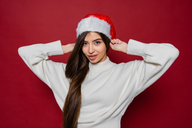 Hermosa mujer europea con pelos largos en sombrero de santa posando