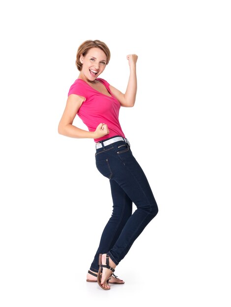 Hermosa mujer feliz celebrando el éxito de ser un ganador con expresión enérgica dinámica aislada en blanco