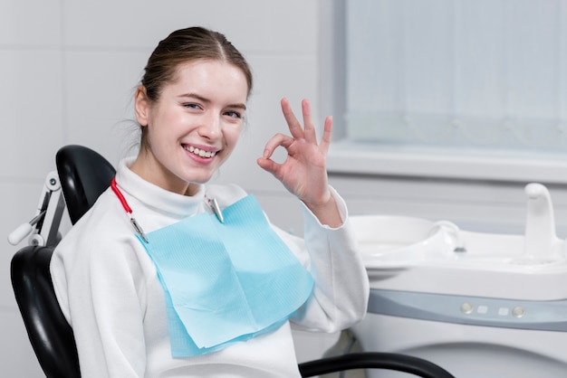 Hermosa mujer feliz en el dentista