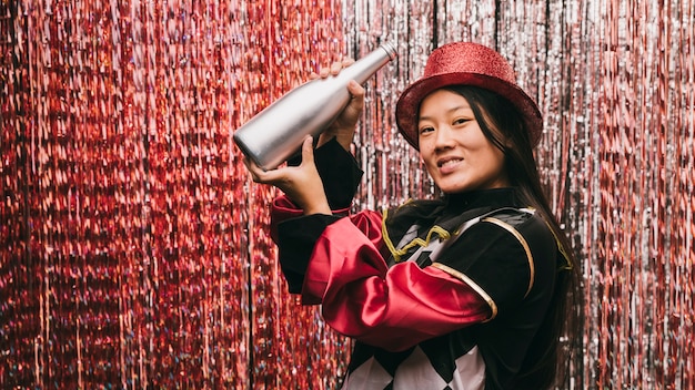 Hermosa mujer en fiesta de carnaval con botella de champagne