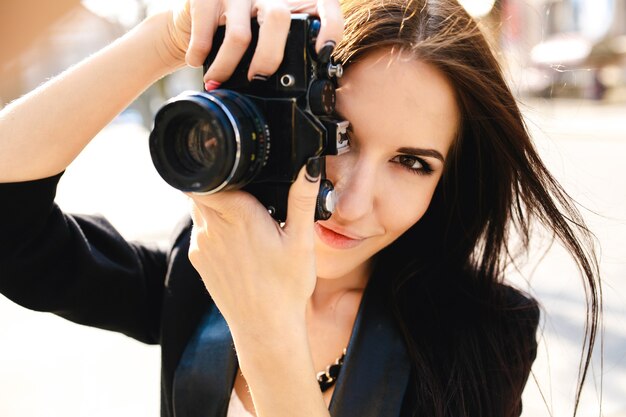 Hermosa mujer fotógrafa posando con cámara