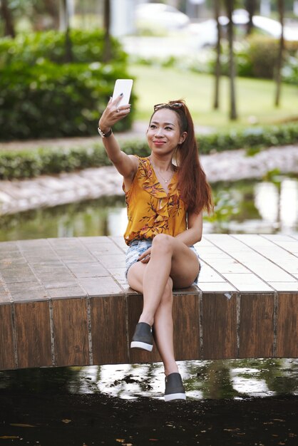 Hermosa mujer fotografiando al aire libre