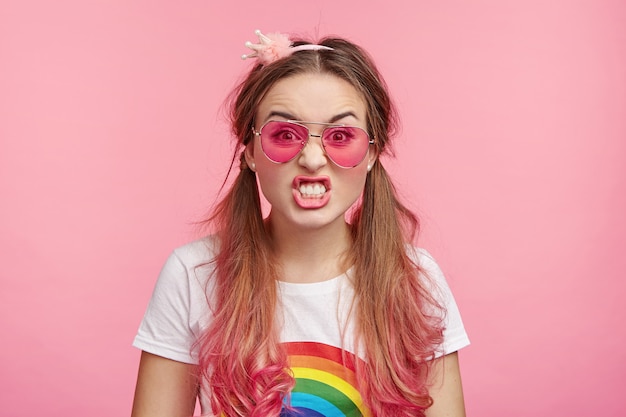 Hermosa mujer con gafas de sol rosa de moda