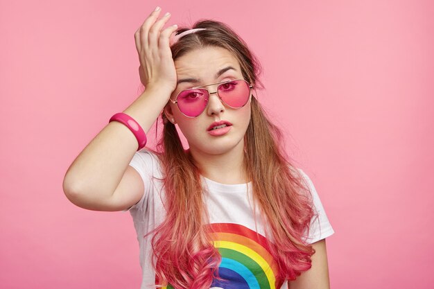 Hermosa mujer con gafas de sol rosa de moda