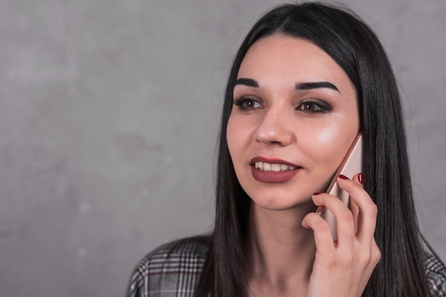 Foto gratuita hermosa mujer hablando en teléfono inteligente