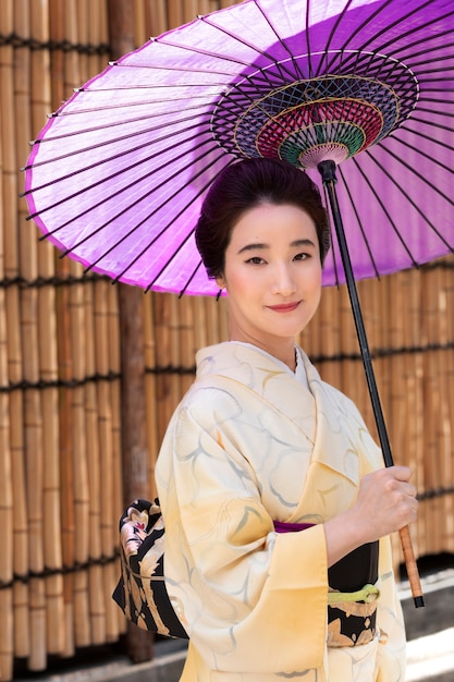 Hermosa mujer japonesa con un paraguas morado