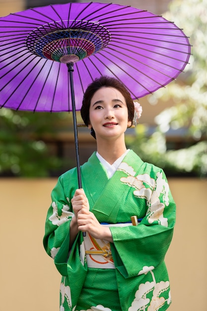 Hermosa mujer japonesa con un paraguas morado