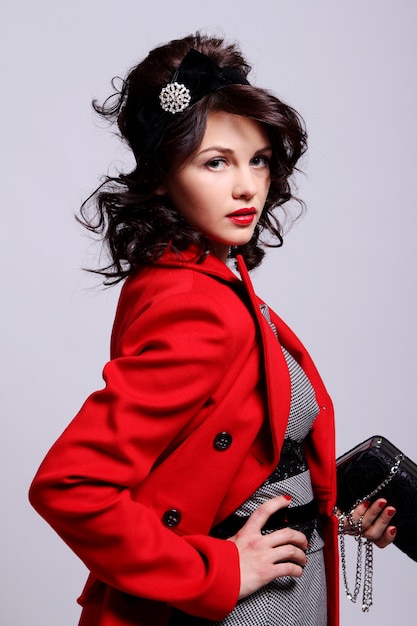 Hermosa mujer joven en abrigo rojo