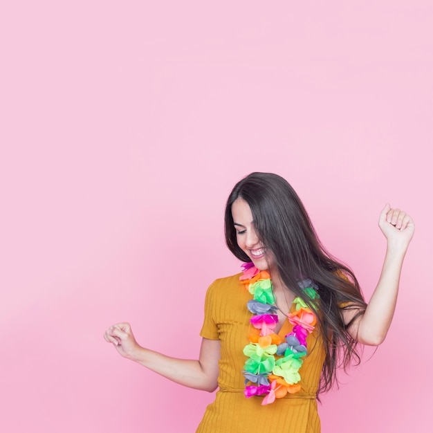 Hermosa mujer joven bailando sobre fondo rosa