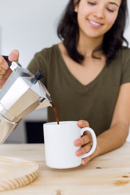 Hermosa mujer joven beber café en casa.