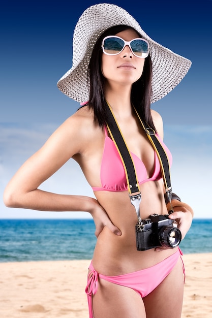 Hermosa mujer joven con bikini celebración vintage cámara retro