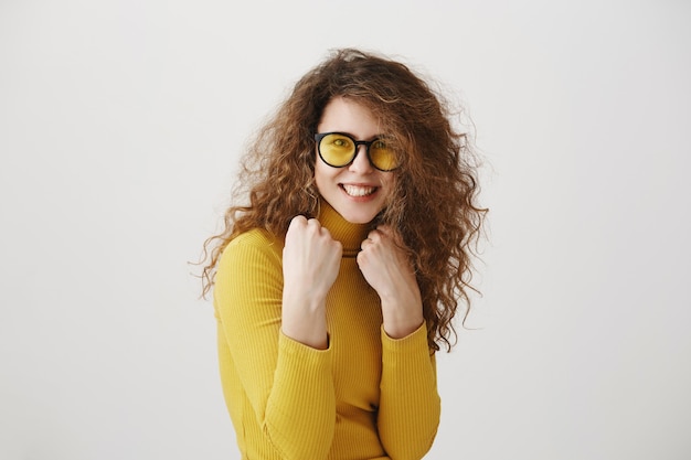 Hermosa mujer joven en un boxeador de pie posando sobre un fondo gris. El poder y la igualdad de las mujeres - concepto.