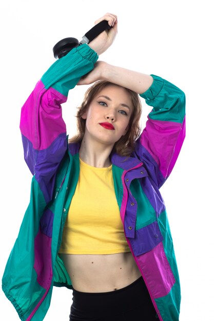 Hermosa mujer joven en chaqueta colorida y con auriculares